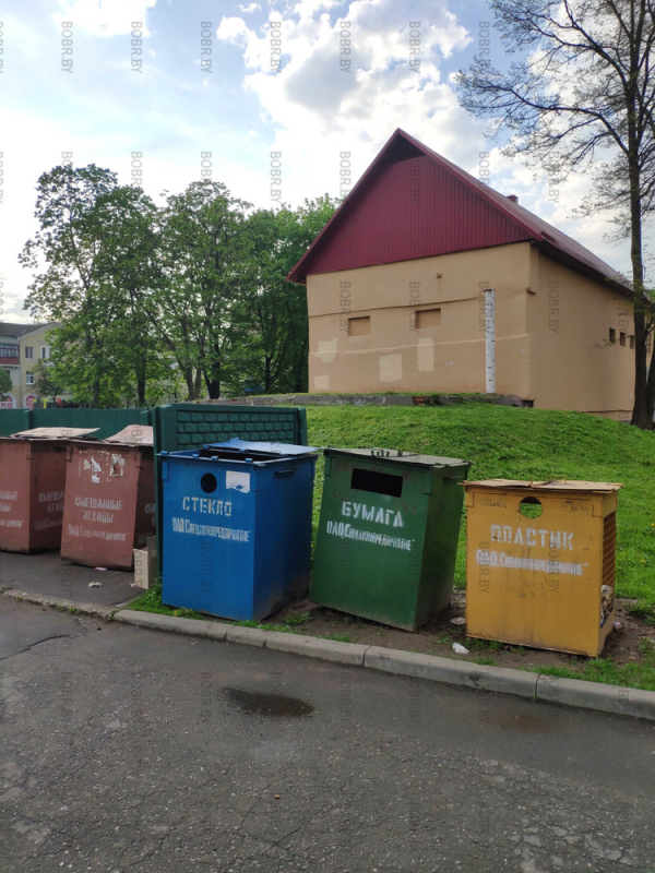 Контейнеры для мусора стоят на зелёной зоне они она специально предназначенные для них площадке