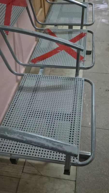 Железные стулья в больнице, где на первом этаже не жарко. Как сидеть на них? В шубе надо приходить.