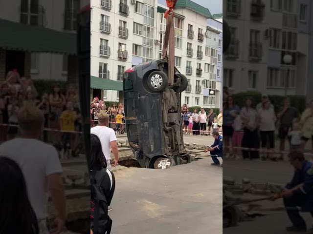 Машину тянут крюком из разлома в асфальте на ул. Социлистической. Бобруйск, 1 сентября 2024